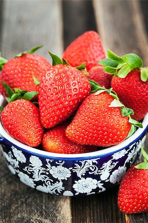 simsearch:400-08672192,k - Fresh organic ripe strawberry in a bowl on wooden table Photographie de stock - Aubaine LD & Abonnement, Code: 400-08669475