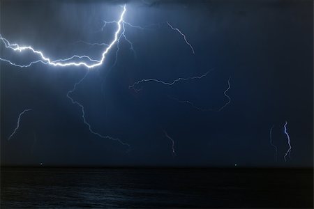simsearch:400-08506969,k - Bolt of lightening in a night sky during a thunderstorm with copy space in a weather or meteorology concept Photographie de stock - Aubaine LD & Abonnement, Code: 400-08669569