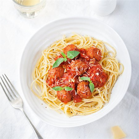 Meatballs in tomato sauce and fresh basil with spaghetti on a white background Top view Photographie de stock - Aubaine LD & Abonnement, Code: 400-08669861