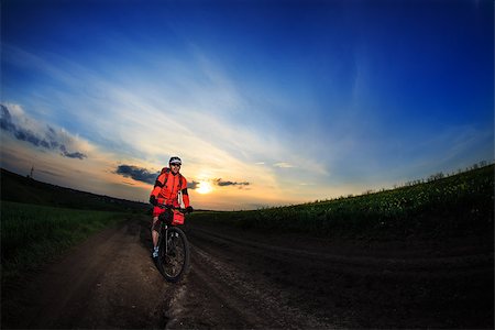 simsearch:400-05681317,k - Man on mountain bike rides on the trail on a beautiful sunset. Wide view Stock Photo - Budget Royalty-Free & Subscription, Code: 400-08678635