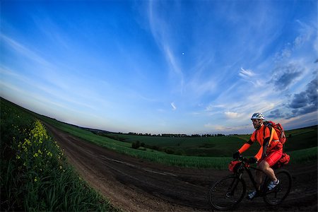 simsearch:400-09141350,k - Man on mountain bike rides on the trail on a beautiful sunset. Wide view Photographie de stock - Aubaine LD & Abonnement, Code: 400-08678631