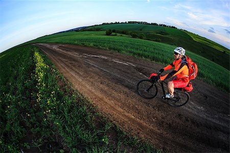 simsearch:400-09141350,k - Man on mountain bike rides on the trail on a beautiful sunset. Wide view Photographie de stock - Aubaine LD & Abonnement, Code: 400-08678632