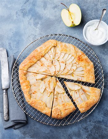 Apple galette, pie, tart with cinnamon on cooling rack on a blue stone background. Top view Photographie de stock - Aubaine LD & Abonnement, Code: 400-08670411