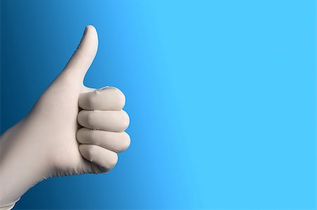 Hand with a white surgical glove showing the thumb up sign against a blue background Stock Photo - Budget Royalty-Free & Subscription, Code: 400-08670718