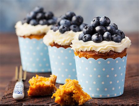 Pumpkin cupcakes decorated with cream cheese frosting and fresh blueberries on a wooden background Copy space Photographie de stock - Aubaine LD & Abonnement, Code: 400-08671083