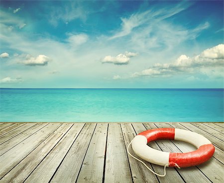 simsearch:400-04319767,k - Wood pier with ocean and life preserver and blue sky in background Stock Photo - Budget Royalty-Free & Subscription, Code: 400-08671529