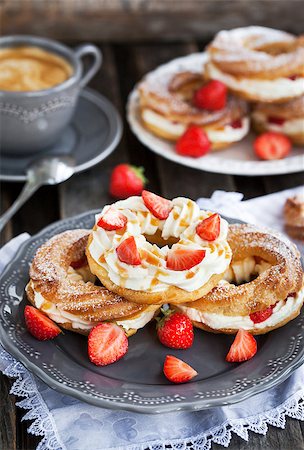 profiterole cake - Cream puff rings (choux pastry) decorated with fresh strawberry and caramel sauce Stock Photo - Budget Royalty-Free & Subscription, Code: 400-08672892