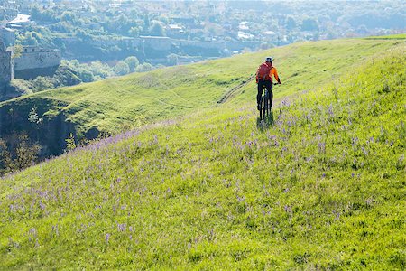 simsearch:400-08298519,k - Cyclist in orange jersey on the Beautiful Meadow Trail Photographie de stock - Aubaine LD & Abonnement, Code: 400-08673565