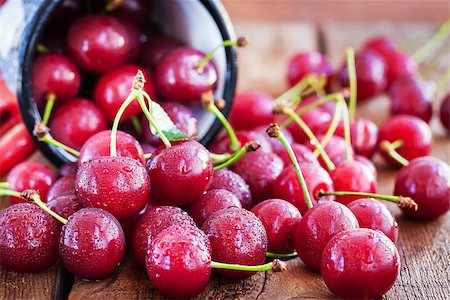 simsearch:400-08672192,k - Sweet fresh ripe cherry pour out of a mug on rustic wooden table Photographie de stock - Aubaine LD & Abonnement, Code: 400-08673683