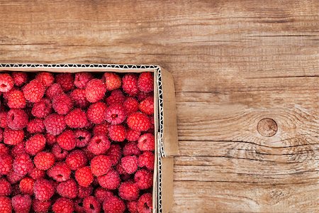 simsearch:400-08672192,k - Fresh organic ripe raspberry in box on wooden table with copy space Photographie de stock - Aubaine LD & Abonnement, Code: 400-08673694
