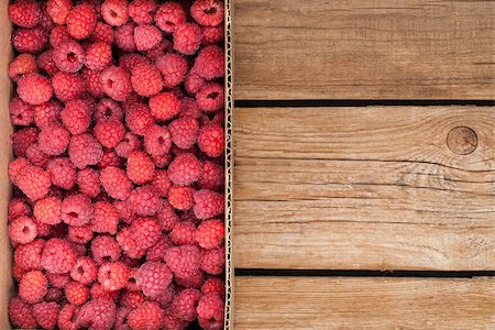 simsearch:400-08672192,k - Fresh organic ripe raspberry in box on wooden table with copy space Photographie de stock - Aubaine LD & Abonnement, Code: 400-08673695