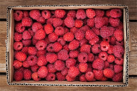 simsearch:400-08672192,k - Fresh organic ripe raspberry in box on wooden table Photographie de stock - Aubaine LD & Abonnement, Code: 400-08673691