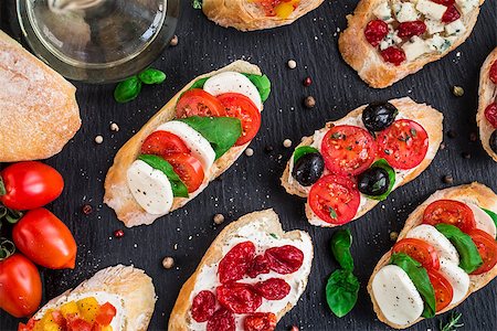 sandwich rustic table - Italian bruschetta with cherry tomatoes, herbs, olives, mozzarella on toasted crusty ciabatta bread Stock Photo - Budget Royalty-Free & Subscription, Code: 400-08694097