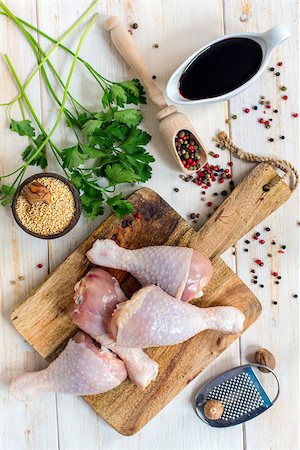 raw chicken on cutting board - Raw chicken drumsticks, sesame and spices on a white table. Stock Photo - Budget Royalty-Free & Subscription, Code: 400-08694356