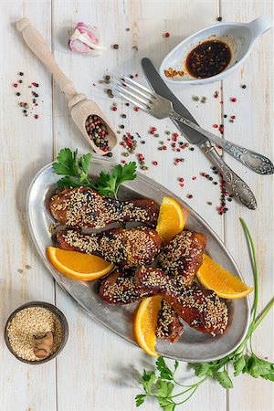 raw chicken on cutting board - Chicken drumsticks with sesame and orange on a white wooden table. Stock Photo - Budget Royalty-Free & Subscription, Code: 400-08694357