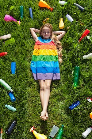 simsearch:696-03396834,k - Young girl happy in the grass surrounded by plastic waste - unaware of the danger Stock Photo - Budget Royalty-Free & Subscription, Code: 400-08694586