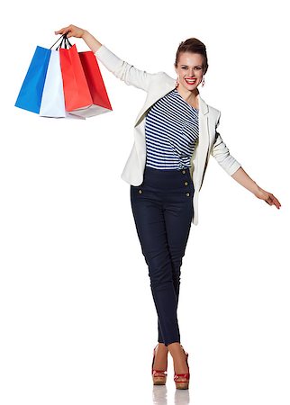 Shopping. The French way. Full length portrait of happy young woman with French flag colours shopping bags balancing on white background Stock Photo - Budget Royalty-Free & Subscription, Code: 400-08694634