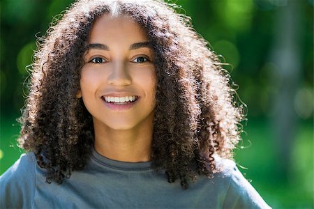 Outdoor portrait of beautiful happy mixed race African American girl teenager female young woman smiling with perfect teeth Stock Photo - Budget Royalty-Free & Subscription, Code: 400-08694962