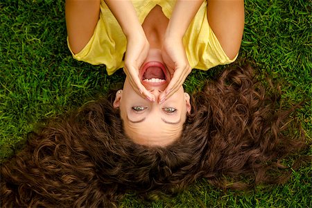 fun park mouth - Portrait of a beautiful and happy young woman lying on the grass Stock Photo - Budget Royalty-Free & Subscription, Code: 400-08695055