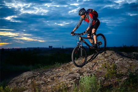 simsearch:400-09132505,k - Cyclist Riding the Bike Down Hill on the Mountain Rocky Trail at Sunset. Extreme Sports Foto de stock - Super Valor sin royalties y Suscripción, Código: 400-08695395