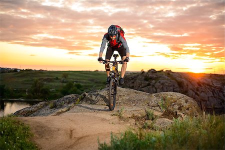 simsearch:400-06788686,k - Cyclist Riding the Bike Down Hill on the Mountain Rocky Trail at Sunset. Extreme Sports Foto de stock - Super Valor sin royalties y Suscripción, Código: 400-08695393