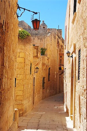 One of the many peaceful shady streets in golden-stone walled city of Mdina. Fotografie stock - Microstock e Abbonamento, Codice: 400-08695426