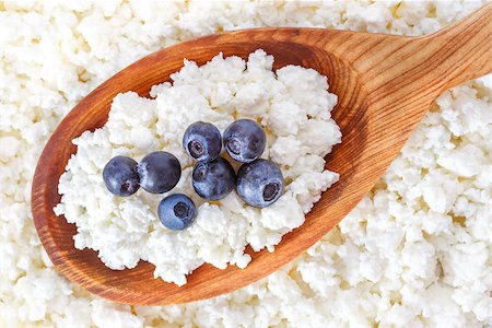 crumbly cottage cheese in the wooden spoon with blueberries on the top Stockbilder - Microstock & Abonnement, Bildnummer: 400-08695946