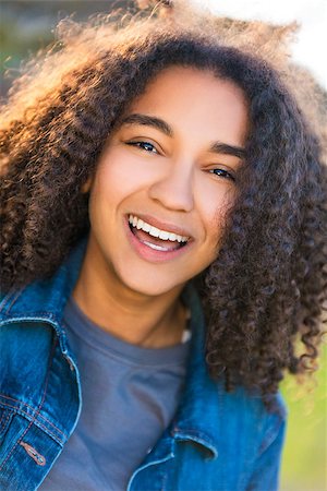 Outdoor portrait of beautiful happy mixed race African American girl teenager female young woman smiling laughing with perfect teeth Stock Photo - Budget Royalty-Free & Subscription, Code: 400-08696094