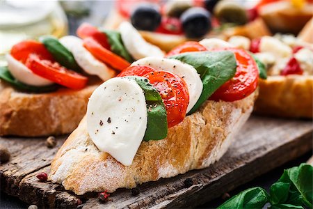 sandwich rustic table - Italian bruschetta with tomatoes, mozzarella cheese and herbs on a wooden board Stock Photo - Budget Royalty-Free & Subscription, Code: 400-08693003