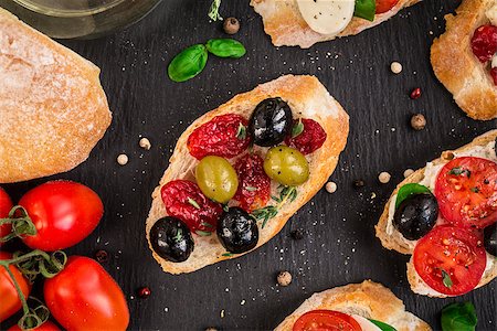sandwich rustic table - Italian bruschetta with cherry tomatoes, herbs, olives, mozzarella on toasted crusty ciabatta bread Stock Photo - Budget Royalty-Free & Subscription, Code: 400-08693018