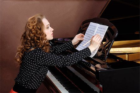 simsearch:400-07338880,k - Young woman musician writes in music book pencil. Sitting in front of grand piano. Stock Photo - Budget Royalty-Free & Subscription, Code: 400-08693039