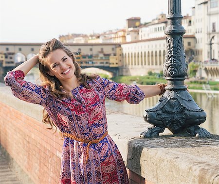 simsearch:400-08020855,k - Remarkable holiday in Florence. Portrait of happy woman in a dress on the embankment near Ponte Vecchio Foto de stock - Super Valor sin royalties y Suscripción, Código: 400-08693171