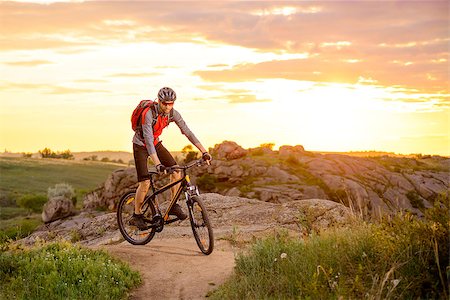 simsearch:400-08298519,k - Cyclist Riding the Bike on the Mountain Rocky Trail at Sunset Photographie de stock - Aubaine LD & Abonnement, Code: 400-08693344