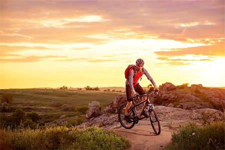 simsearch:400-08673565,k - Cyclist Riding the Bike on the Mountain Rocky Trail at Sunset Photographie de stock - Aubaine LD & Abonnement, Code: 400-08693345