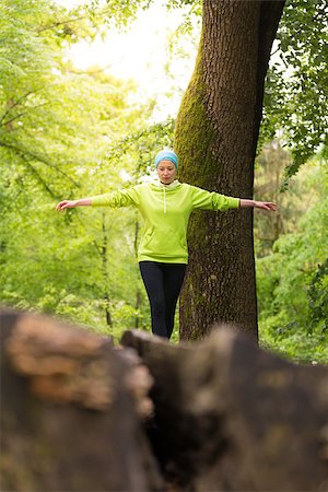 Active sporty woman holding balance on tree trunk while workout in nature. Wellness and healthy lifestyle concept. Stock Photo - Budget Royalty-Free & Subscription, Code: 400-08693925