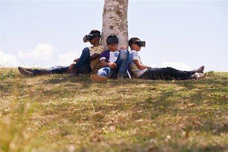 simsearch:400-08621230,k - Youth culture, young people, group of male friends, multiethnic teens playing with VR outdoors, teenagers using virtual reality headset in park, boys and modern technology. Future 3D hi-tech Foto de stock - Super Valor sin royalties y Suscripción, Código: 400-08705708
