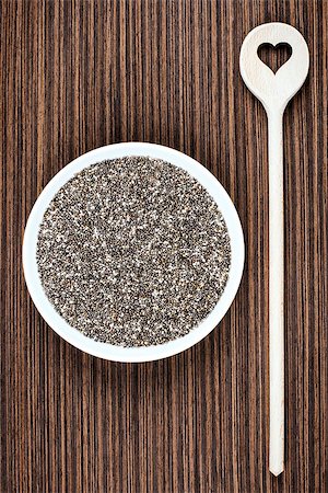 salvia hispanica - Chia seeds on white porcelain plate with cooking wooden spoon (cut heart shape) on wood background table. Photographie de stock - Aubaine LD & Abonnement, Code: 400-08705933