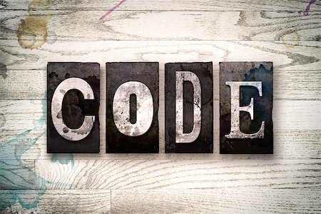 simsearch:400-08709089,k - The word "CODE" written in vintage dirty metal letterpress type on a whitewashed wooden background with ink and paint stains. Foto de stock - Royalty-Free Super Valor e Assinatura, Número: 400-08707709