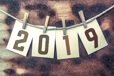 The word "2019" stamped on cards and pinned to an old piece of twine over a rusted metal background. Foto de stock - Royalty-Free Super Valor e Assinatura, Número: 400-08707905