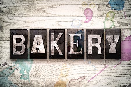 The word "BAKERY" written in vintage, dirty metal letterpress type on a whitewashed wooden background with ink and paint stains. Stock Photo - Budget Royalty-Free & Subscription, Code: 400-08709086