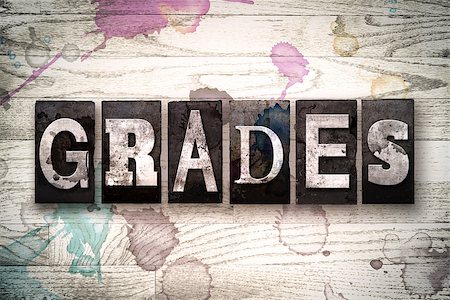 The word "GRADES" written in vintage, dirty metal letterpress type on a whitewashed wooden background with ink and paint stains. Stock Photo - Budget Royalty-Free & Subscription, Code: 400-08709120