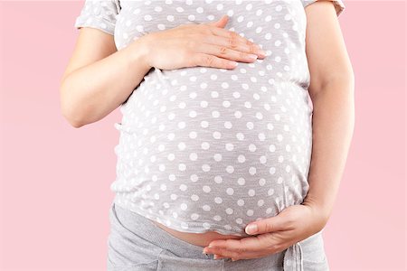 simsearch:400-08529613,k - Pregnant beautiful woman touching big belly isolated on pink background. Pregnancy and motherhood. Stock Photo - Budget Royalty-Free & Subscription, Code: 400-08734470
