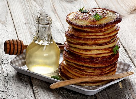 Stack of Delicious Homemade  Pancakes with Mint Leafs, Honey in Glass Container and Honey Dipper in Checkered Tray closeup on Wooden background Stock Photo - Budget Royalty-Free & Subscription, Code: 400-08735258