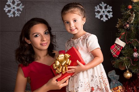 Happy mother with daughter open a Christmas gift Stockbilder - Microstock & Abonnement, Bildnummer: 400-08735541