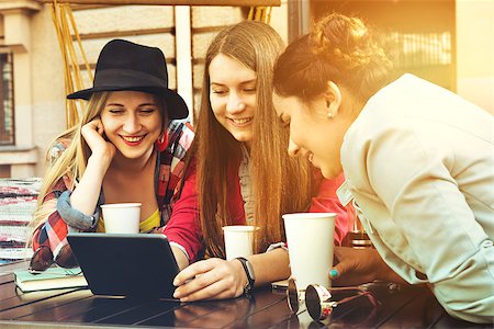 Group of girls sits in coffee house with tablet computer and having fun Stock Photo - Budget Royalty-Free & Subscription, Code: 400-08735596