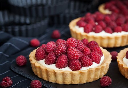 Delicious raspberry mini tarts (tartlets) with whipped cream on dark background Stock Photo - Budget Royalty-Free & Subscription, Code: 400-08736520