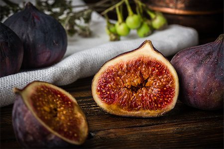 simsearch:400-07718938,k - Half ripe and juicy fig lying on rustic table. Seasonal and exotic fruit Fotografie stock - Microstock e Abbonamento, Codice: 400-08736641
