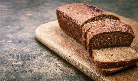 Fresh bread cut on wooden old board in rustic style with copyspace Stock Photo - Budget Royalty-Free & Subscription, Code: 400-08737158