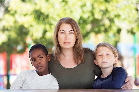 sorry boy pictures - Serious mother sitting in between adopted child and son at table in park Stock Photo - Budget Royalty-Free & Subscription, Code: 400-08737311