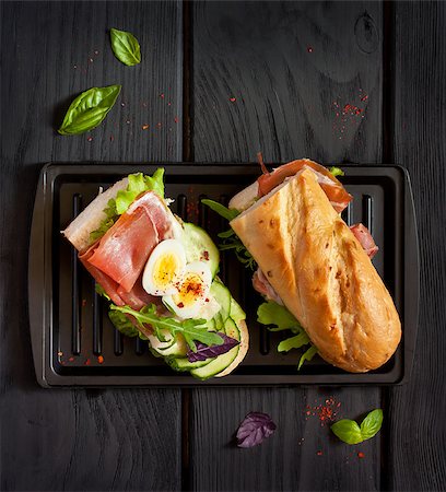 slice of baguette - Fresh egg ham sandwich on dark board. Foto de stock - Super Valor sin royalties y Suscripción, Código: 400-08730040